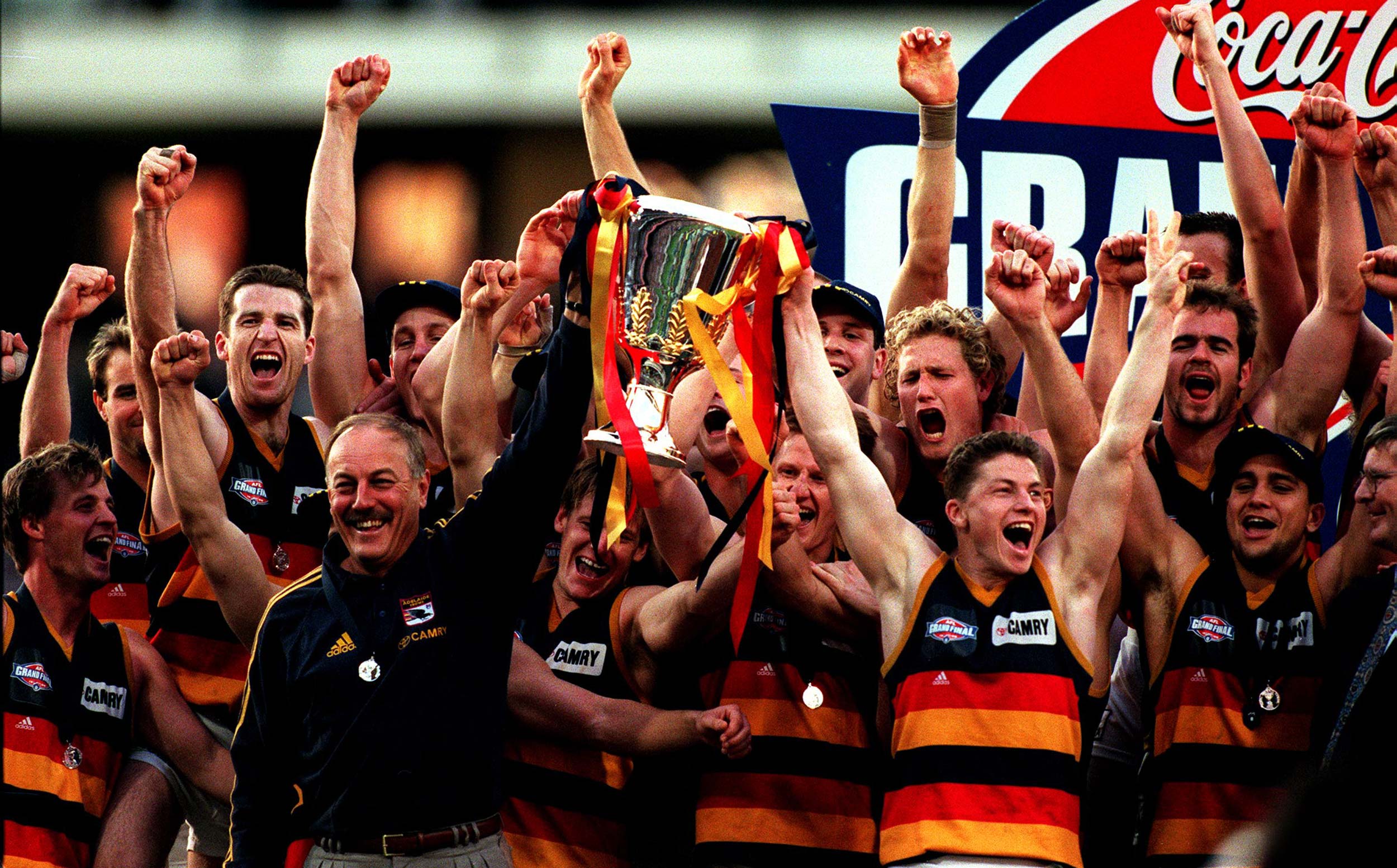   Adelaide Crows coach Malcolm Blight (L) & skipper Mark Bickley hold Premiership Cup aloft at MCG following defeat of North Melbourne in AFL grand final, 26/09/98.
Australian Rules / Trophy
  